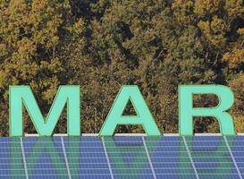 Letters MAR - a name fragment - on a roof reflected by solar panels. photo