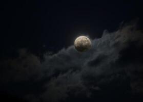 Full moon behind a cloud made visible by an HDR imaging technique. photo