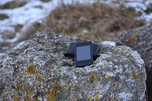 Modern smartphone lying on a stone. photo