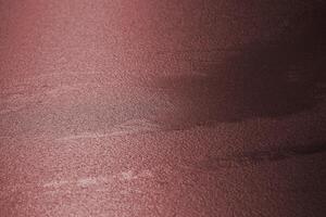 Water surface frozen to a rippled structure with sunlight reflections. The image was toned red to create a new color mood. photo