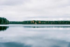 Landscape of blue deep lake in light of sun in tide daytime, clouds in sky, mountains photo