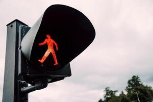 Red traffic light for pedestrians, semaphore background foggy autumn sky photo