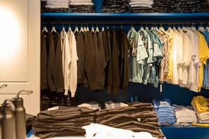 Market sells local nice traditional clothes, fabrics on shelf of store photo