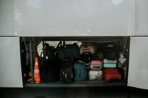 Suitcases of tourists loaded in trunk of bus, transport shuttle tour vacation photo