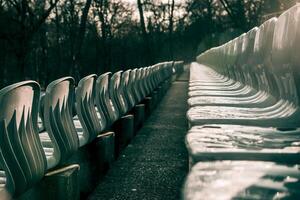 Sector at nice stadium arena, rows of plastic gray seats of amphitheater, cloudy day photo