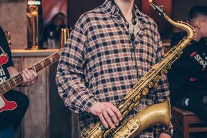 Man play wind nice instrument, musician saxophone performs concert in nightclub bar photo