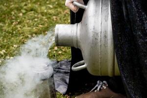 Scientist pour liquid nitrogen large barrel flask, assistant conducts experiment photo