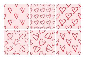Hand-drawn seamless patterns with red hearts on pink background vector