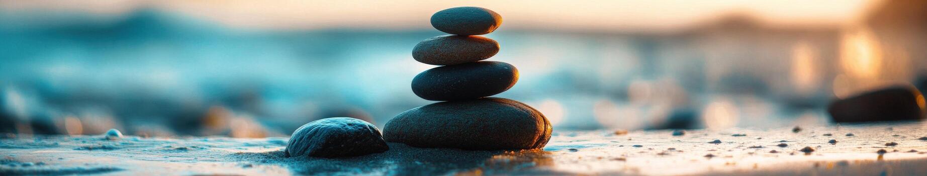 Tranquil stack of smooth stones on a serene beach at sunset photo