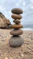 Stacked stones create a balanced formation on a sandy beach by the sea photo