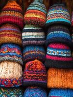 Colorful hand-knit hats stacked in a vibrant marketplace setting photo