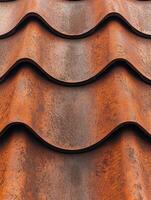 Rusty metal roof tiles creating a textured pattern in sunlight photo