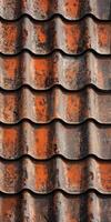 Textured rooftop tiles with weathered orange and brown hues in sunlight photo