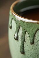 Handcrafted green ceramic mug with unique glaze dripping effect photo