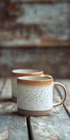 Ceramic mugs resting on a rustic wooden table in a cozy setting photo