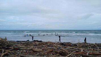 A debris and the surfer with their surfboards in the beach photo