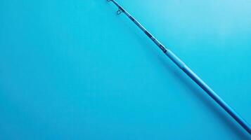 Fishing rod positioned diagonally against a bright blue background for a clean and minimalist look photo