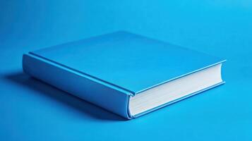 Bright blue book resting on a solid blue background, showcasing its clean cover and spine design photo