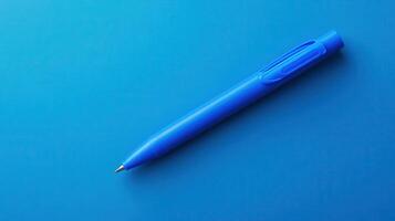 Blue pen resting on a vibrant blue surface creating a minimalistic aesthetic atmosphere in an office setting or study area photo