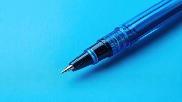 Close-up view of a blue pen resting on a turquoise background showcasing detailed design and fine tip photo