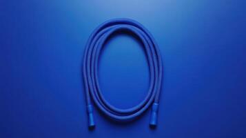 Bright blue skipping rope positioned on a vibrant blue surface for fitness and exercise routines photo
