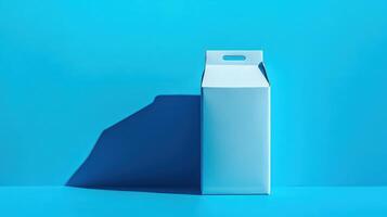 Bright blue backdrop featuring a minimalist milk carton box wrapped in simple design and casting a sharp shadow photo