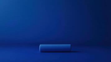 Calm and minimal blue abstract composition featuring a single rolled object on a dark blue surface photo