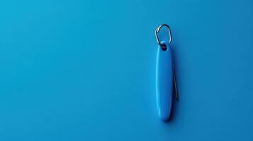 Bright blue keychain resting on a vibrant blue surface creating a minimalistic and modern aesthetic photo