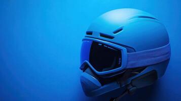 Ski helmet with goggles resting on a blue background, emphasizing winter sports safety gear and style photo
