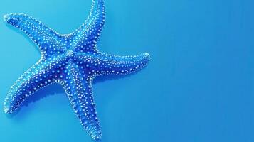Bright blue starfish resting on a vibrant blue background in an underwater habitat photo