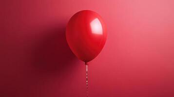 Bright red balloon floating against a vibrant pink wall emphasizing simplicity and color in a minimalist setting photo
