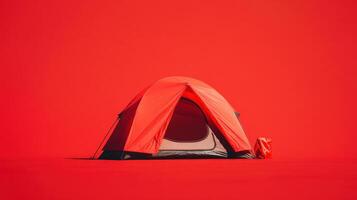 Bright red camping tent set against a vibrant red backdrop in an outdoor environment photo