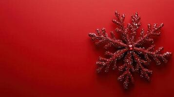 Red glitter snowflake decoration on a vibrant red background ready for winter festivities and holiday celebrations photo