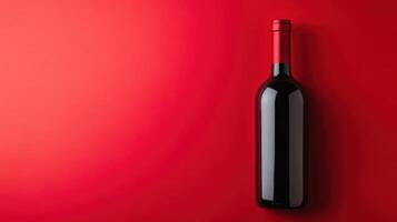 Elegant red wine bottle against a vibrant red background, showcasing simplicity and sophistication in beverage presentation photo