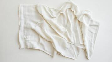 White fabric draped elegantly on a plain surface, showcasing its smooth texture and gentle folds photo