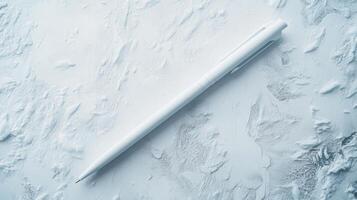 White pen rests on textured surface, creating a minimalistic aesthetic for artistic expression and creativity photo