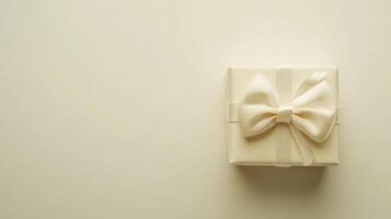 Small white gift box with ribbon placed on neutral background ready for celebration or special occasion photo