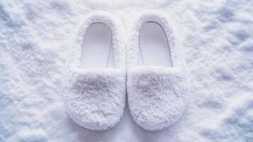 Cozy white fluffy slippers resting on a soft blanket in a well-lit indoor setting during the winter season photo