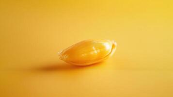 Bright yellow lemon resting on a vibrant yellow surface showcasing its glossy skin and fresh appearance photo