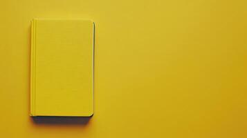 Bright yellow book resting on a solid yellow background creates a striking visual contrast in a minimalist style photo