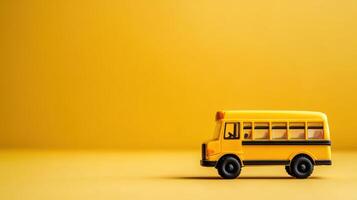 Bright yellow toy school bus on a vivid yellow background, illustrating childhood memories and playful themes photo