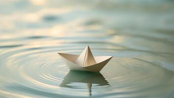 A paper boat floating on top of a body of waterA paper boat floating on top of a body of water. photo