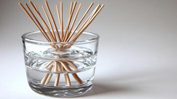 A delicate aroma diffuser showcases wooden reeds placed in water, enhancing tranquility photo