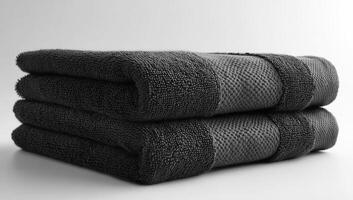 Black towels arranged for a clean look. Soft black towels stacked neatly on a smooth surface showcasing elegant texture and color photo