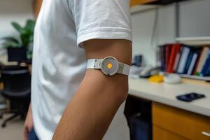 A person monitors their glucose levels with a sensor on their arm in a stylish, contemporary office environment. photo
