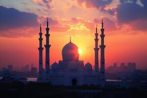 The vibrant sunset casts colorful hues behind a majestic mosque, highlighting its intricate architecture and minarets photo