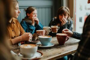 A group of people sitting at a table with coffee cups photo