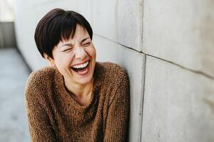 Portrait of a joyful drag queen in vibrant attire laughing against a striking red background photo