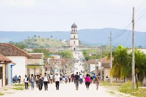 Vibrant street life in Cuba with faded colors and historical architecture under a clear sky photo