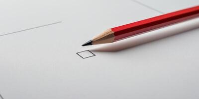Red pencil is checking the box on a checklist on a white notebook photo